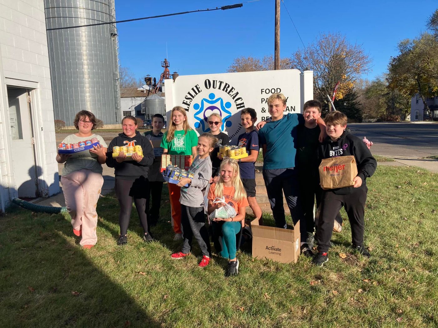 Leslie kids delivering canned goods to the outreach